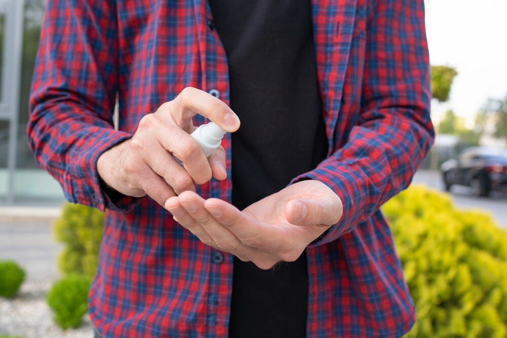 Unrecognizable man using sanitizer on hands